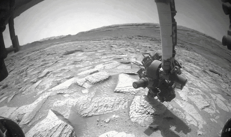 Gif of Curiosity attempting to shake a Martian rock loose