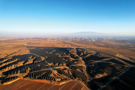 Aerial view of a large solar farm in a desert landscape.