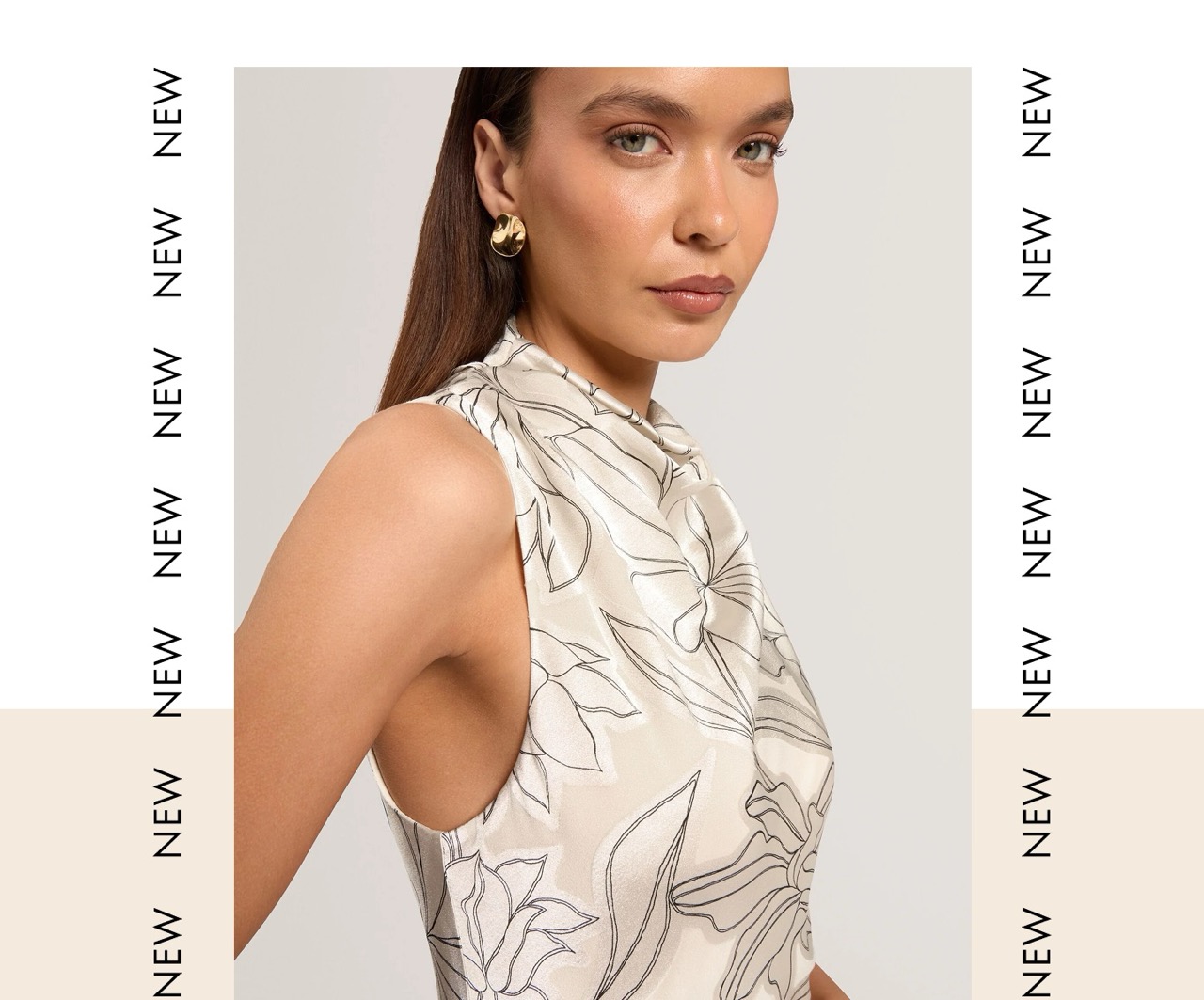 New – woman in cream floral high-neck top with gold hoop earrings