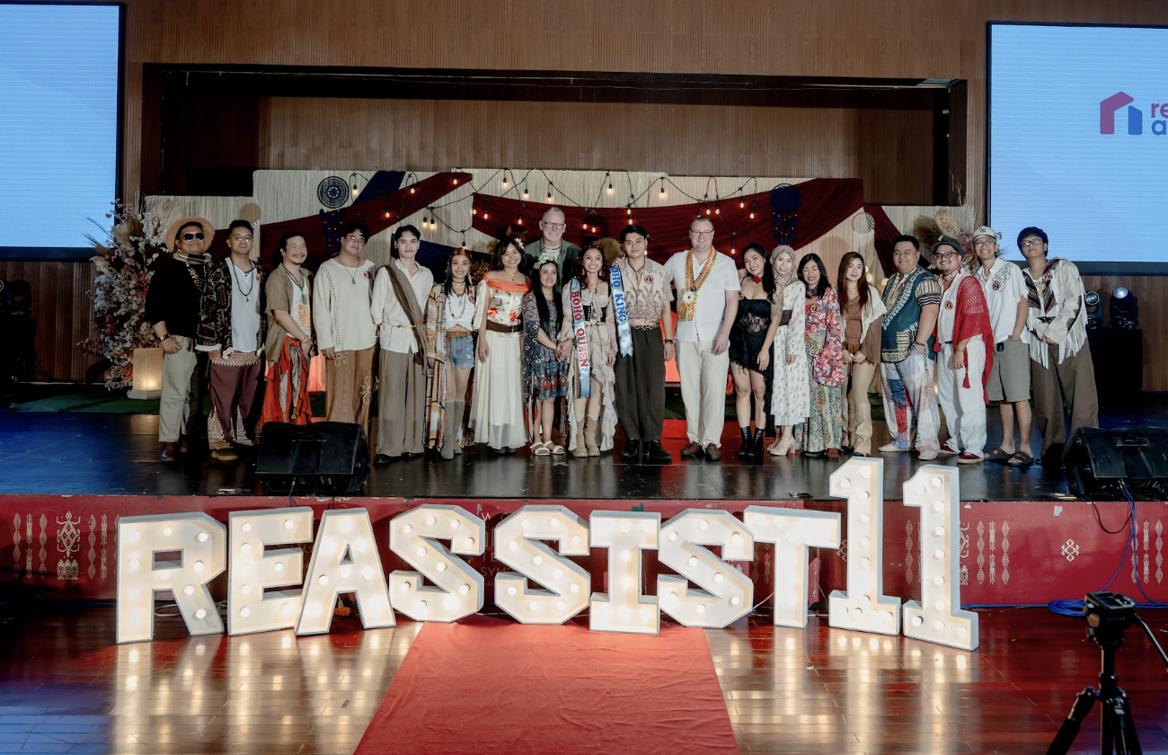 REassist team celebrating 11th anniversary in bohemian outfits in front of REassist11 sign