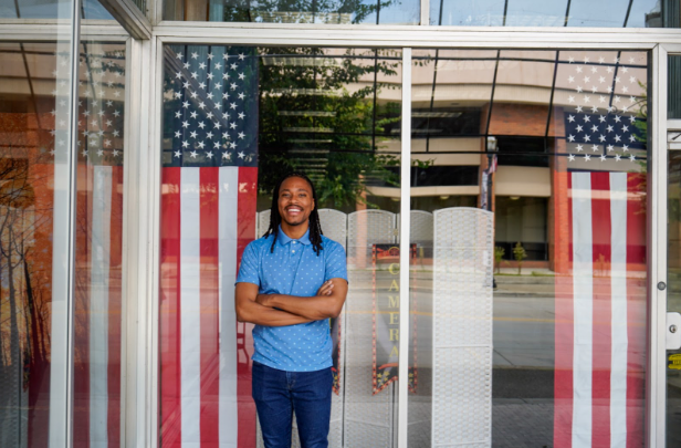 Malcolm Kenyatta posing for a photo next to the American flag.