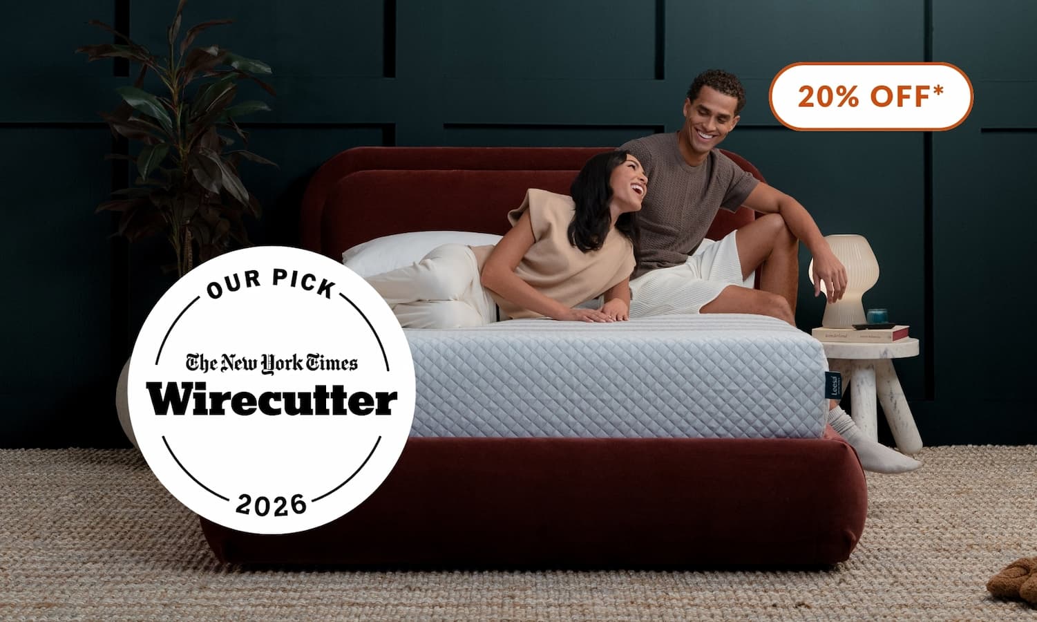 Couple sitting on Wirecutter's pick for Best Hybrid Mattress, the Sapira Hybrid