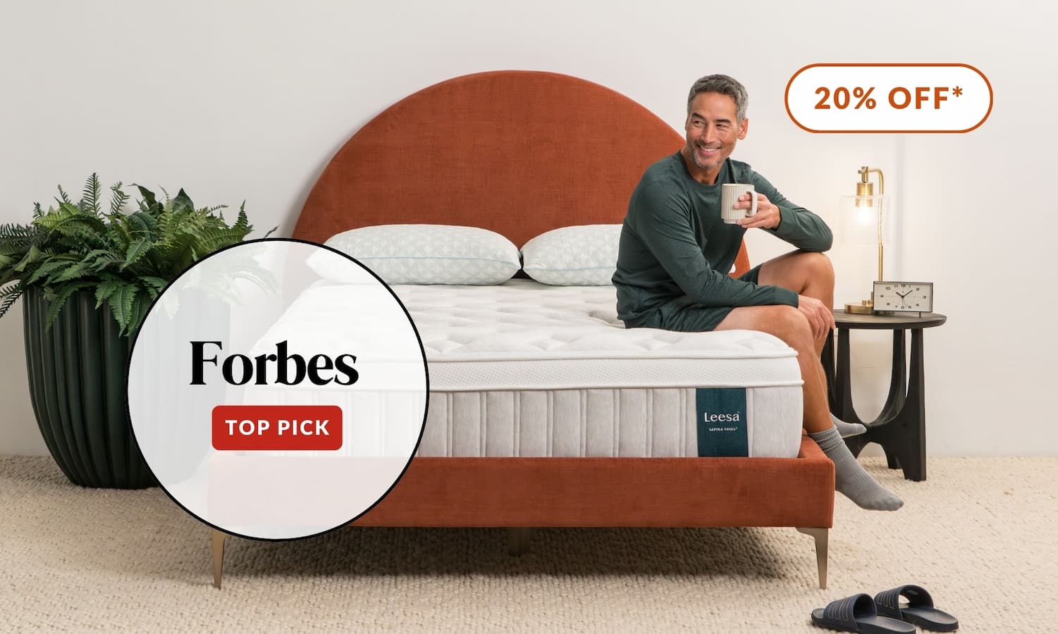 Man sitting on Forbes' pick for Best Hybrid Mattress, the Sapira Chill