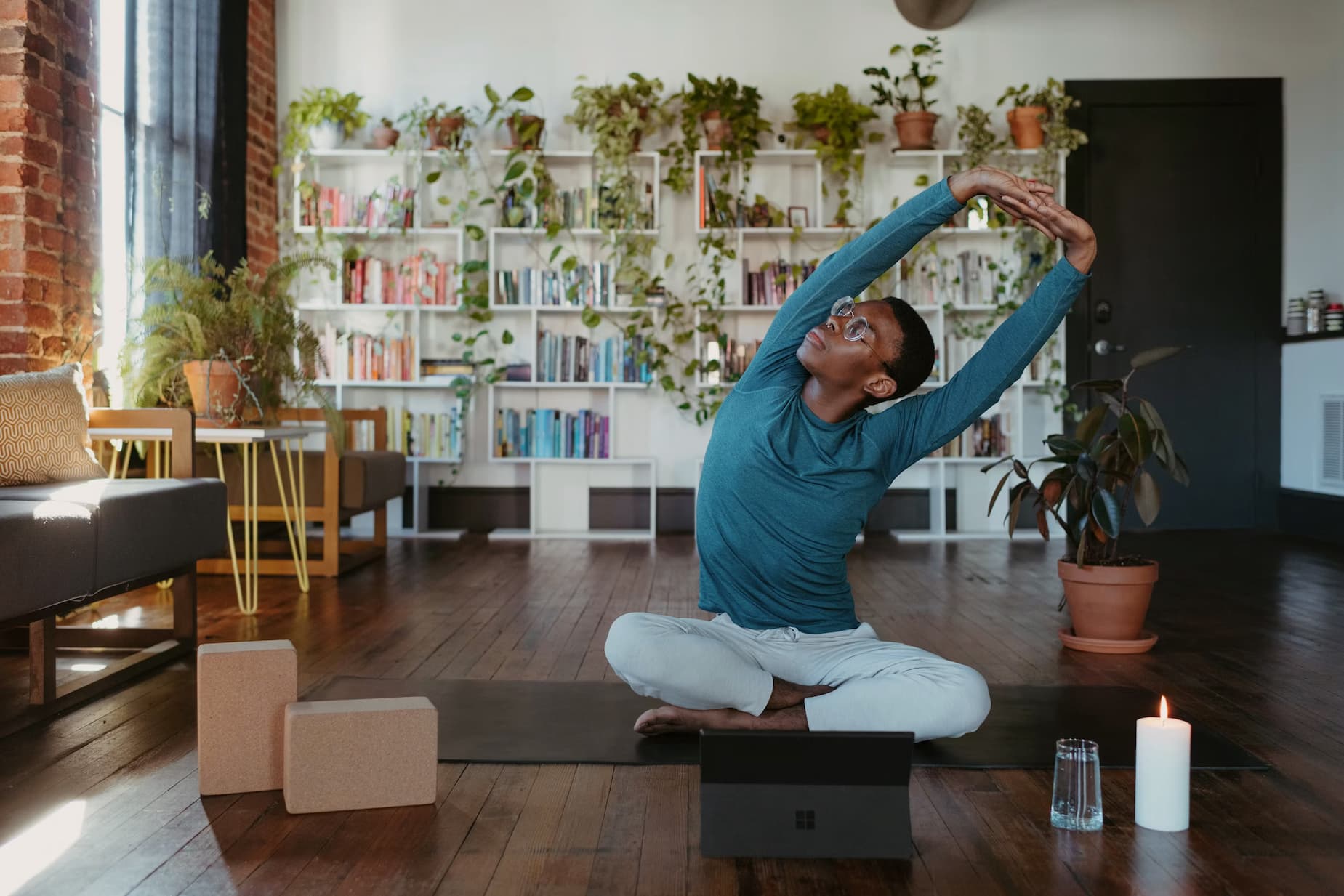 Woman stretching on a yoga mat in a living room.