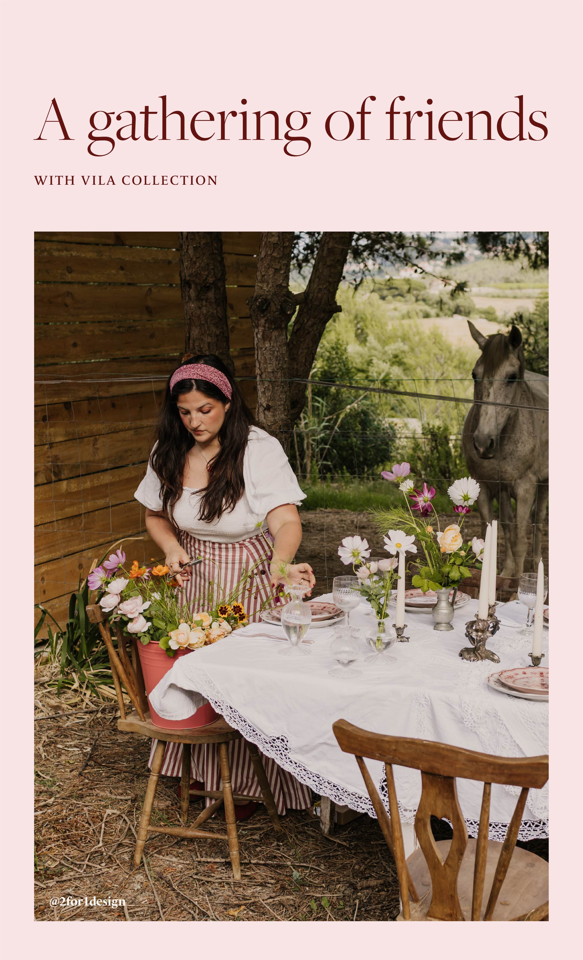 A gathering of friends, with Vila collection. Woman with a headband and striped skirt setting an outdoor table with Vila tableware, wildflowers, candles and glasses, next to a wooden fence with a horse in the background. Caption below describes the table styled by 2for1design for The Hosting Season, featured in Lux Décor