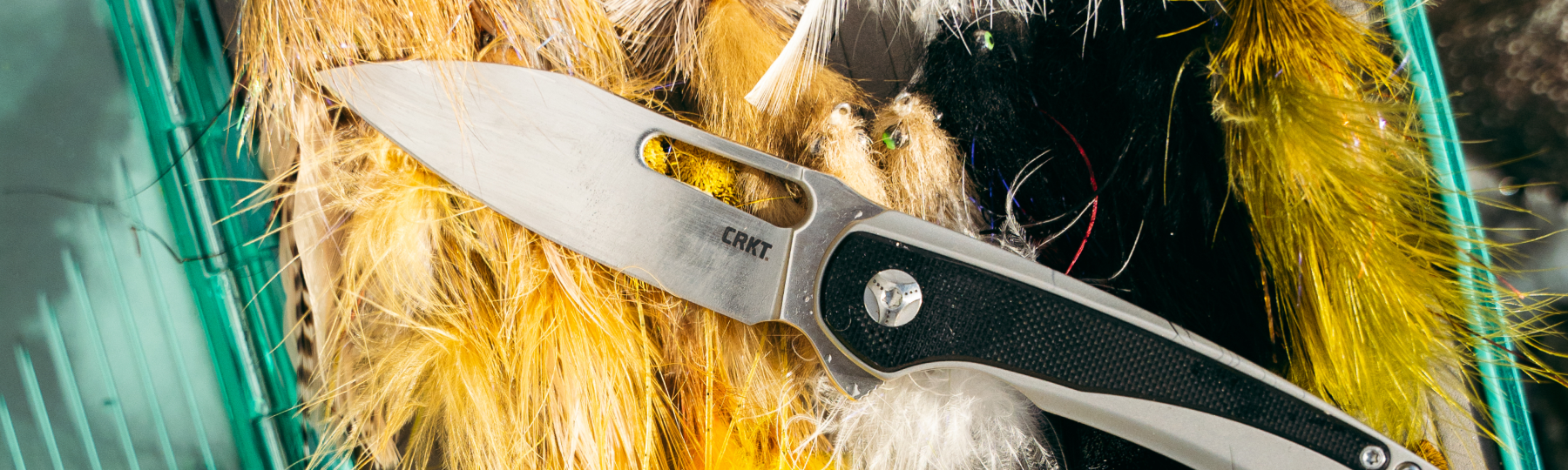 Folding knife showcased alongside fishing tackle.