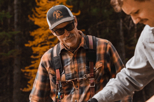 Animated scene of a father and son working together on an outdoor woodworking project.