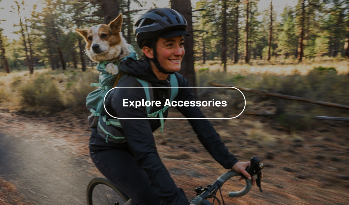 A dog sits in backpack while human carries them on a bike