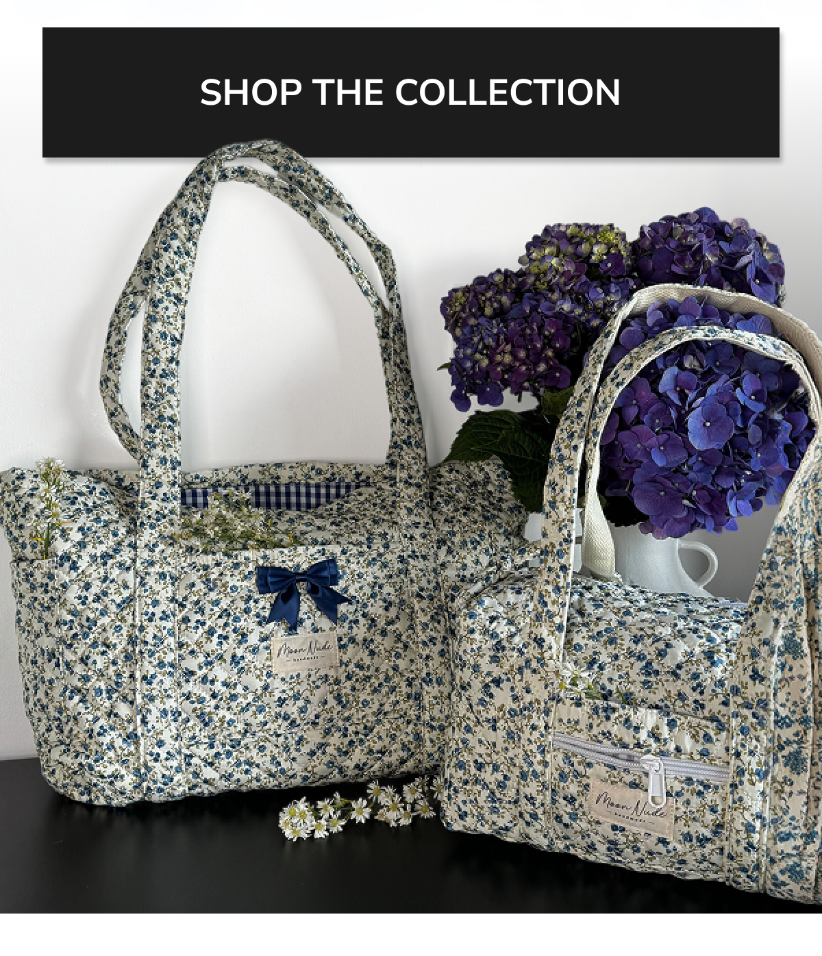 Two floral-patterned bags next to a vase of purple flowers.