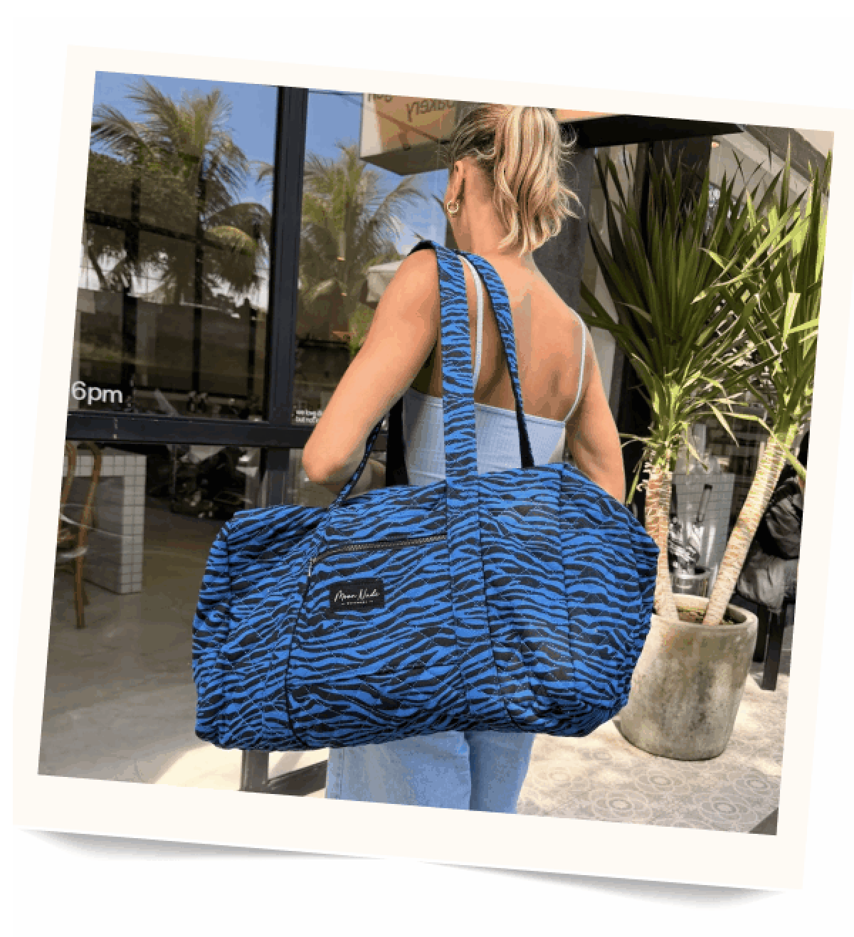Blue zebra print duffel bag on a woman.