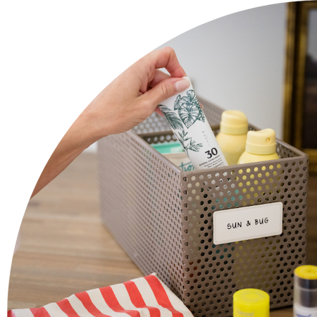 Perforated basket holding sun block and bug spray in the mudroom