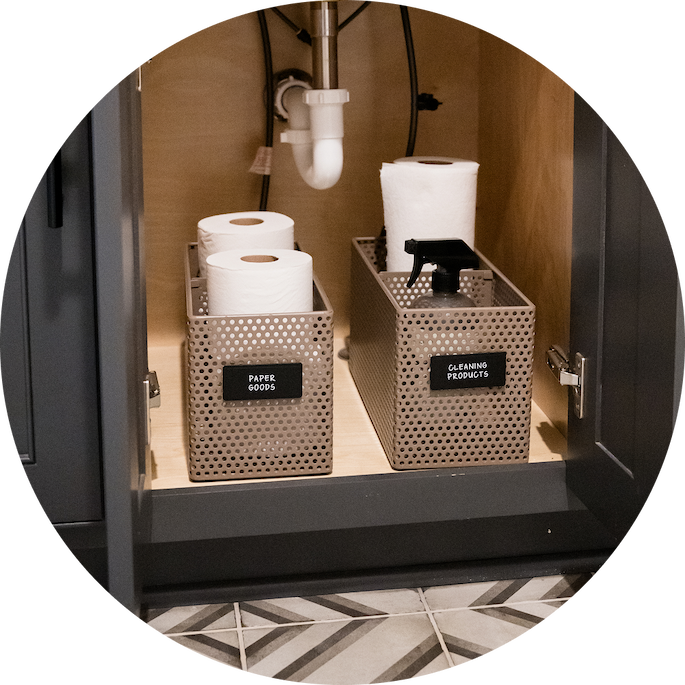 Small perforated baskets holding cleaning items under the sink