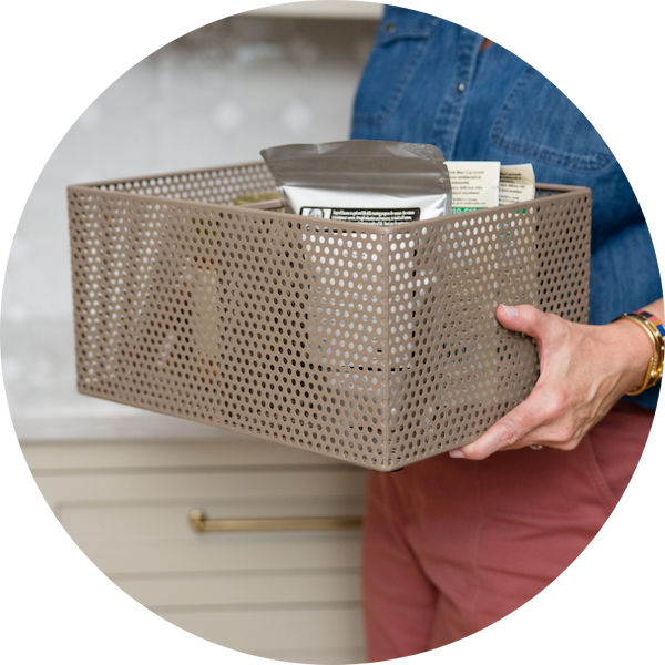 A person holding a perforated basket