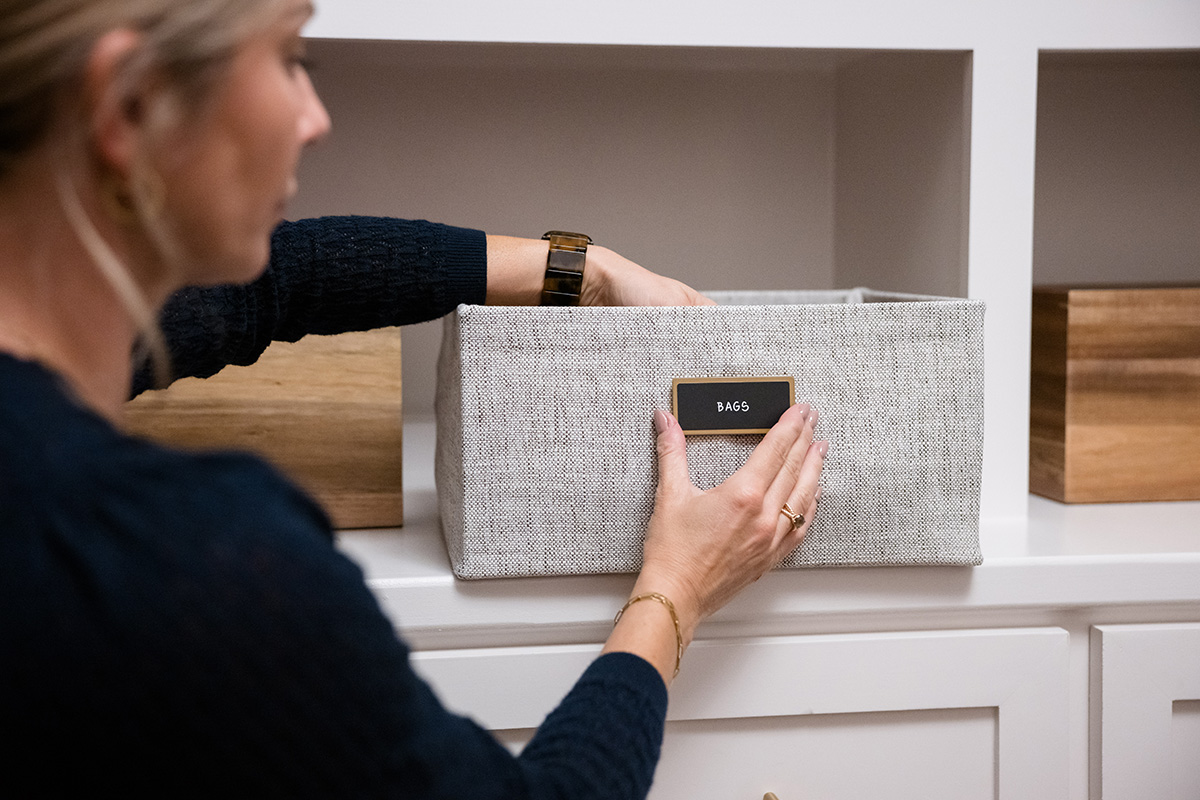 A woman fixing a label to an Oxford Bin