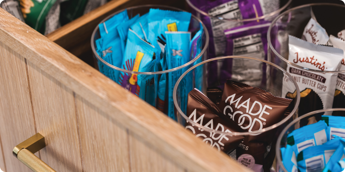 Glass jars holding packaged snacks in a drawer