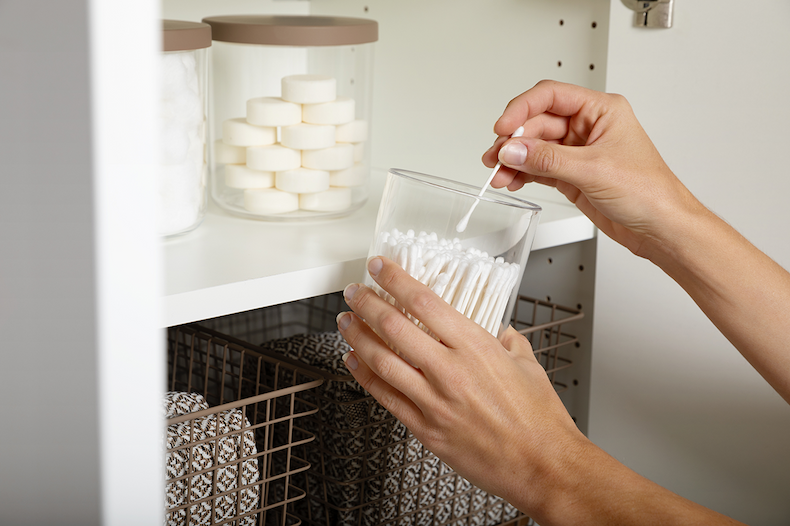 Canisters and grid baskets in a bathroom closet