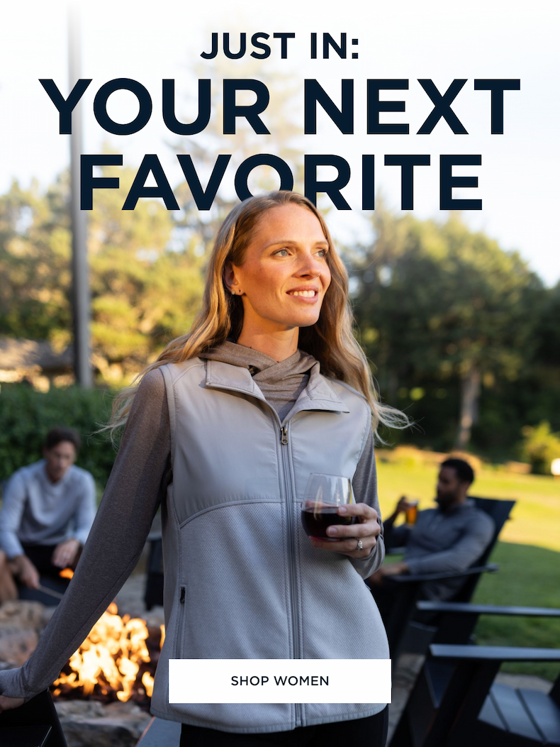 Woman wearing Hunter's Point vest while standing by the fire and drinking wine | Shop Women