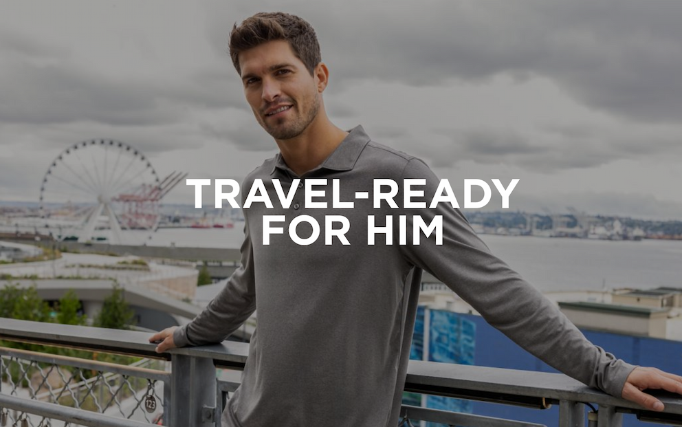 Man smiling learning against a railing near the pier with a ferris wheel in the background