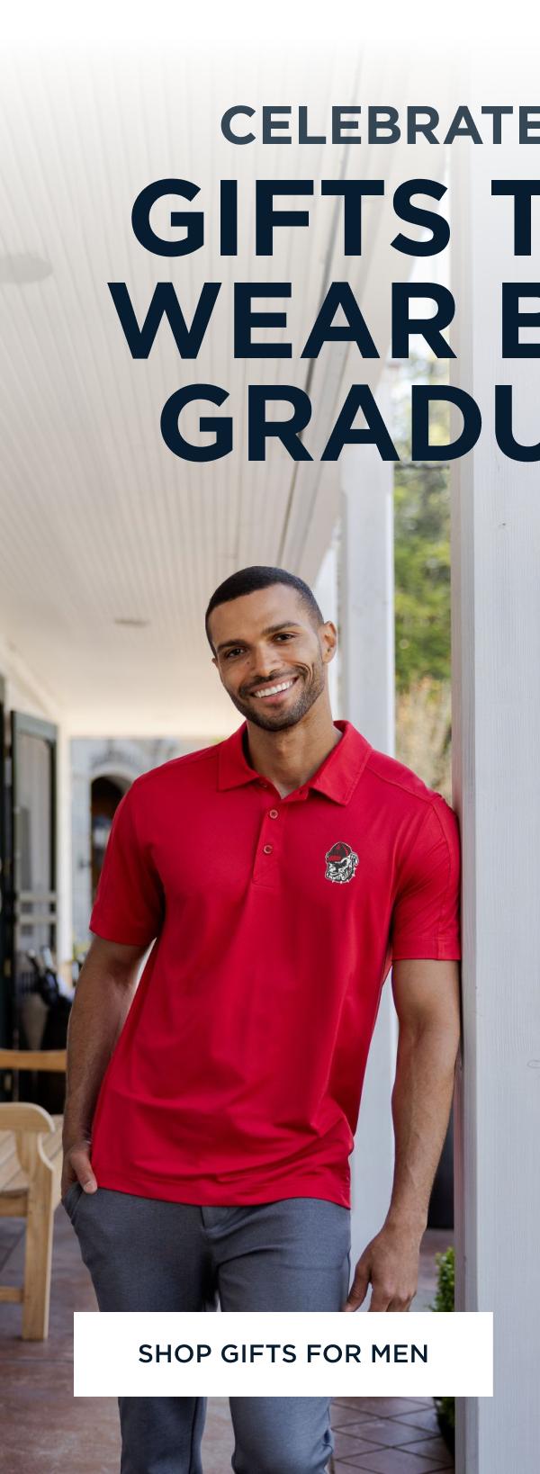 Man wearing a red polo shirt leaning on a column | Shop Gifts For Men
