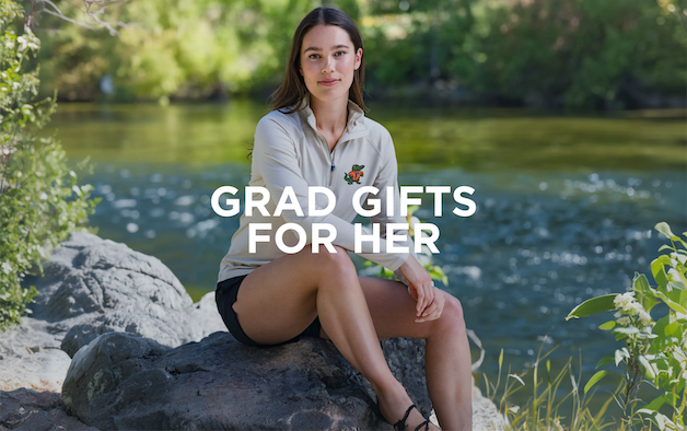 Woman wearing a wheat colored quarter zip pullover and sitting by the river | Grad Gifts For Her