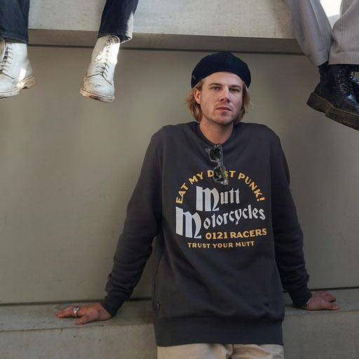 A model wears a grey Mutt sweatshirt, saying "Eat my dust punk!". He is also wearing a black beanie and sunglasses.