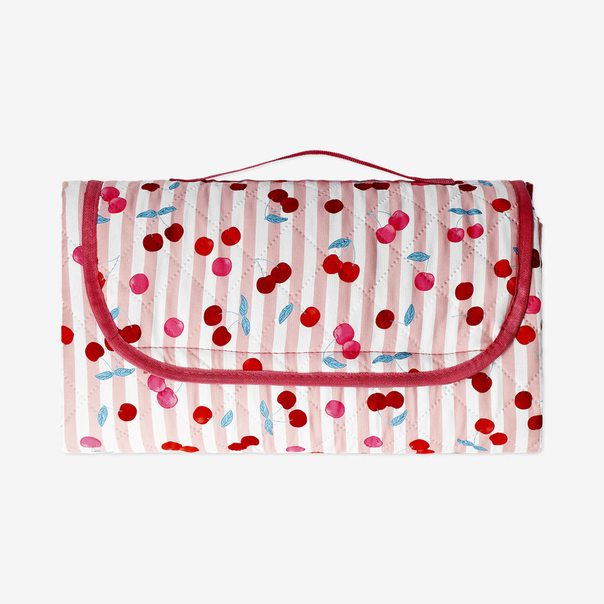 Quilted picnic blanket with berry print and carrying strap