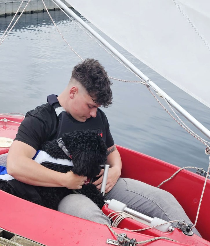 Image of Rooster Rider, Logan, with his dog in a boat