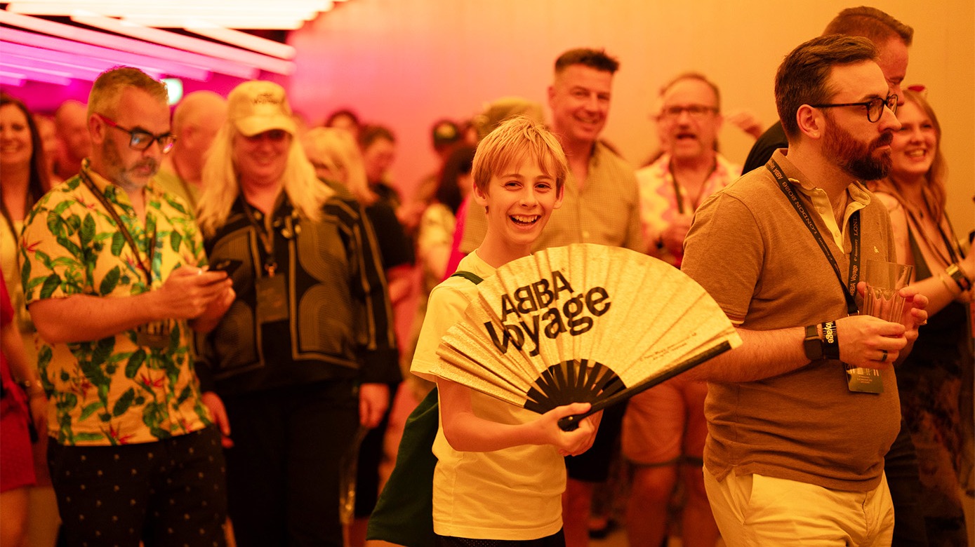 Smiling boy with an ABBA Voyage fan