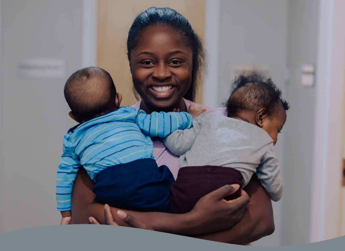 A new mom holding two babies