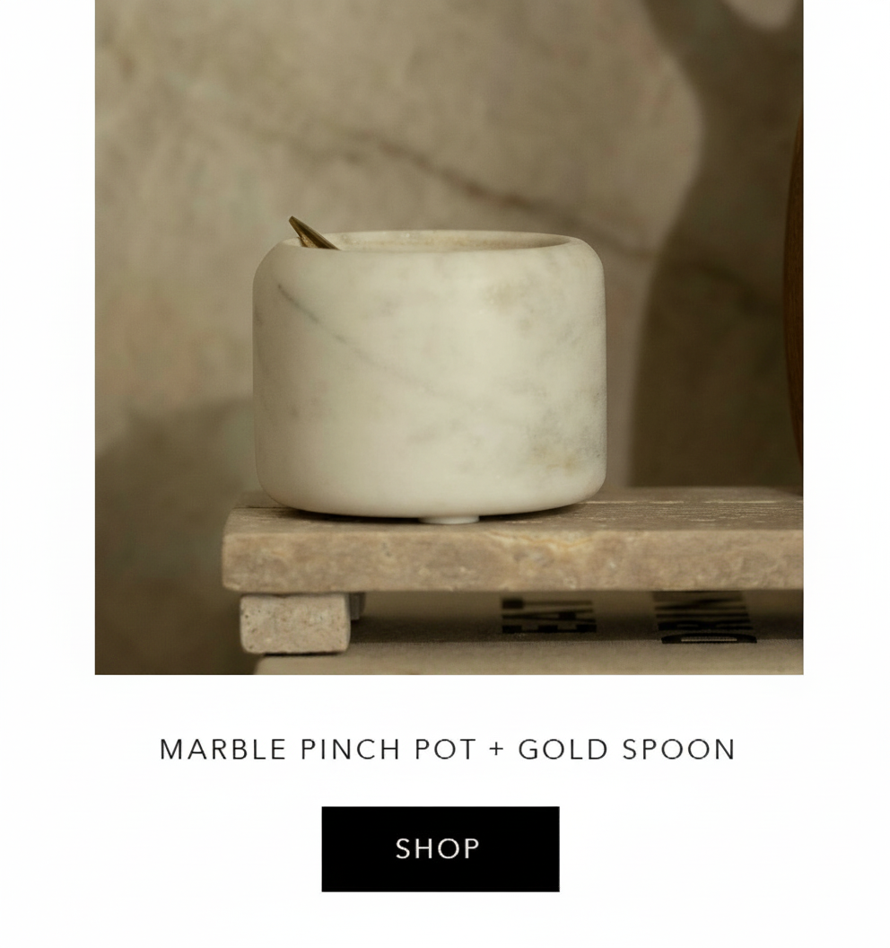 an image of a marble pot and gold spoon on a wooden stand