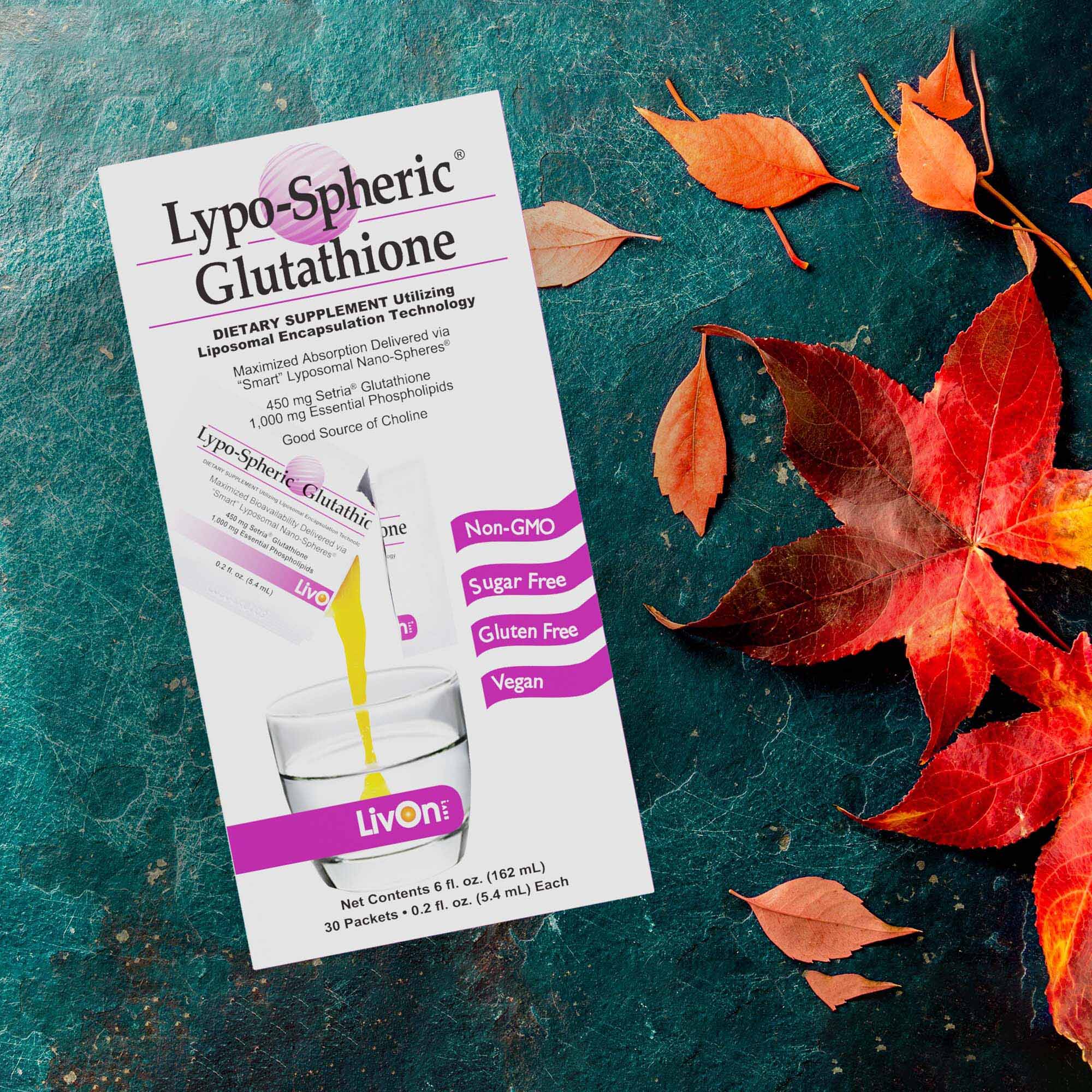carton of lypo-spheric glutathione on a green surface with red leaves