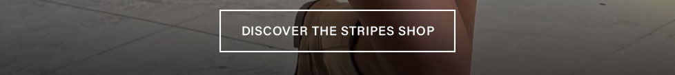White button with 'DISCOVER THE STRIPES SHOP' text over a beige striped garment, inviting users to explore striped fashion apparel.