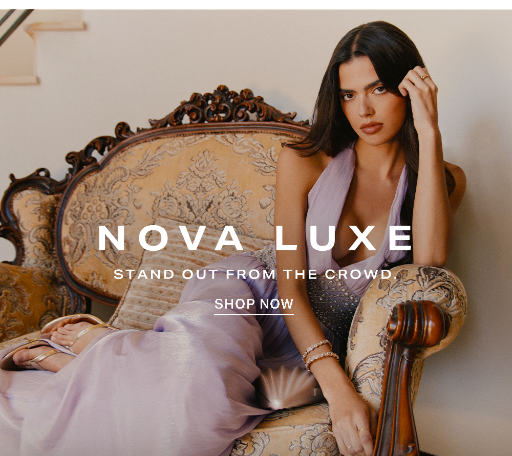 Woman in an elegant lavender Nova Luxe evening gown with intricate details, gracefully reclining on a gold ornate sofa. Shop Nova Luxe.