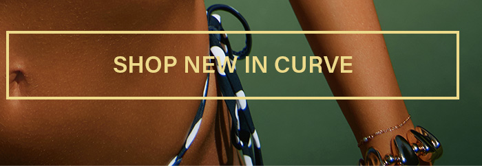 Torso and arm of a model in a black polka dot bikini top, accented with gold jewelry. Shop new arrivals in the curve collection now.