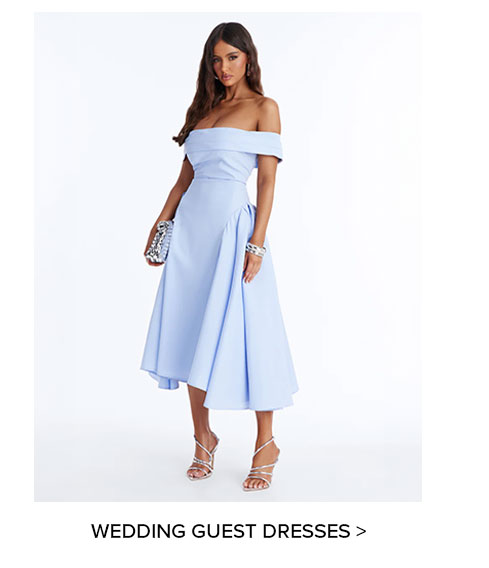 Stylish woman in a light blue off-shoulder midi dress with a full skirt, silver clutch, and strappy heels, perfect for wedding guests.