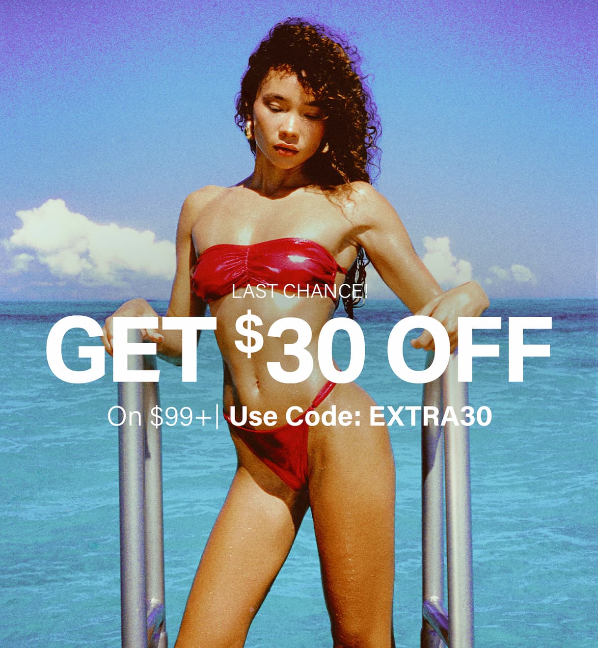 Get $30 OFF $99+ on swimwear! Last chance, use code EXTRA30. Woman in red bikini by tropical water.