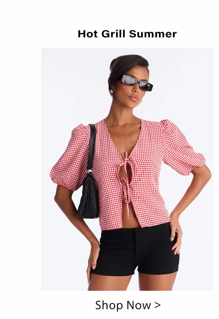 Woman in red gingham tie-front top with puffed sleeves, black shorts, sunglasses, and shoulder bag. Perfect casual summer style.