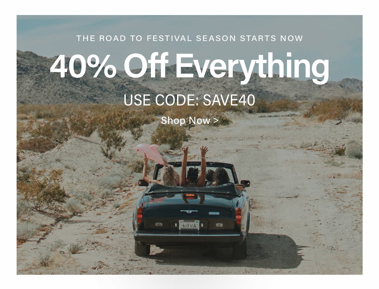 Dark convertible with women driving desert road, arms up, for 40% off everything festival season sale with code SAVE40.