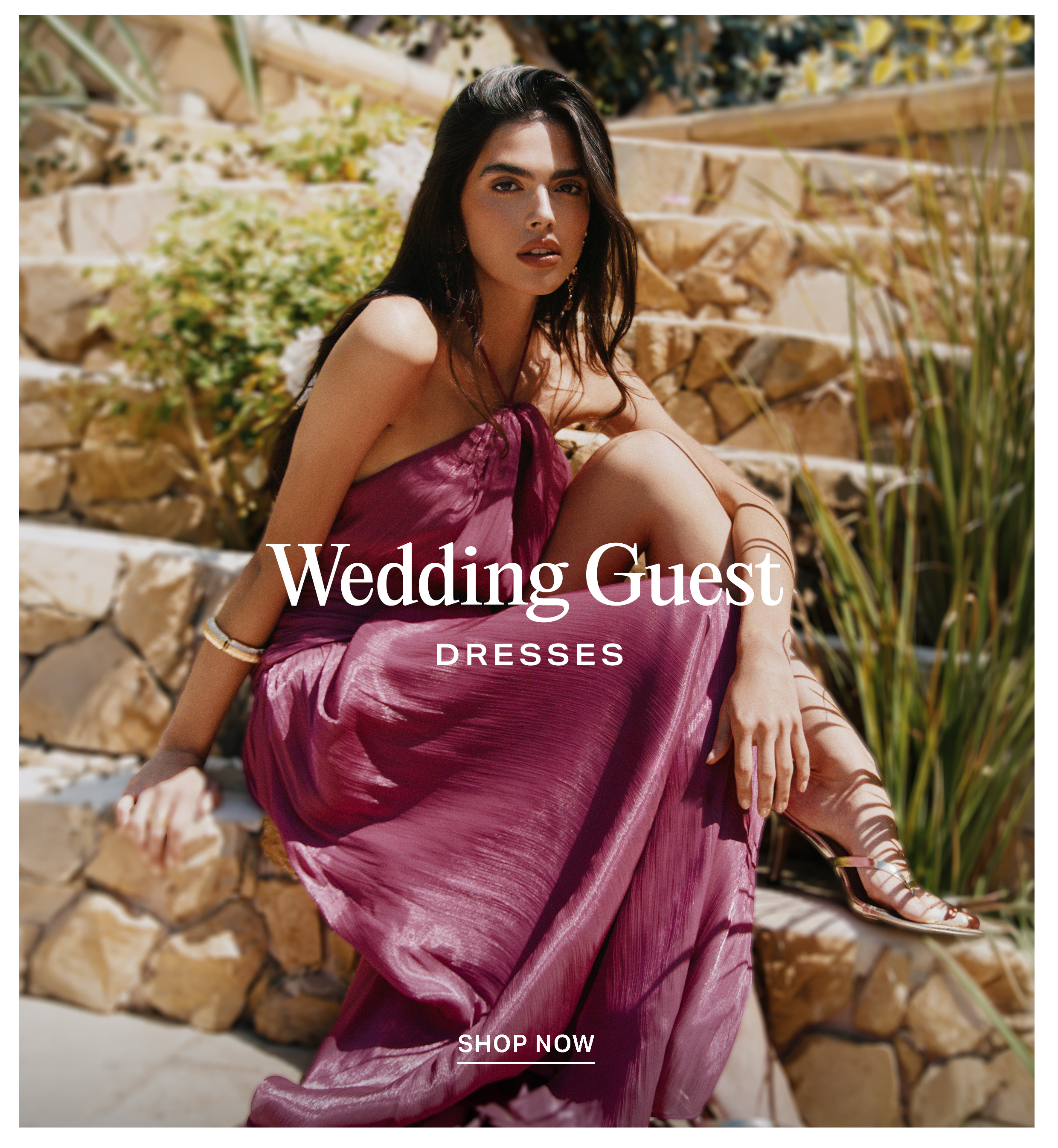 Woman wearing a metallic magenta maxi dress on sunny stone stairs, promoting "Wedding Guest Dresses" with a "Shop Now" call to action button.
