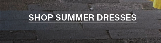 White 'SHOP SUMMER DRESSES' text, underlined, on a dark charcoal brick background, inviting users to browse the summer dress collection.