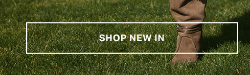 Brown suede boots on green grass. New arrivals banner for a fresh collection of stylish footwear, perfect for exploring.