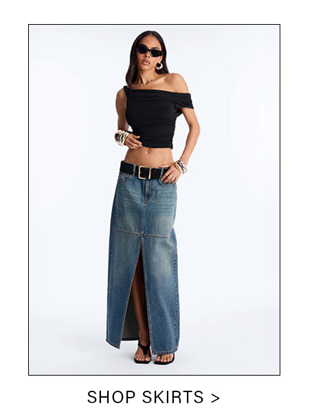Model wearing a black off-shoulder crop top and a long blue denim maxi skirt with a front slit, promoting stylish skirts.