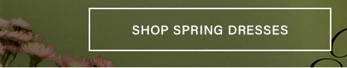 Pink fringed flowers on an olive green backdrop. A prominent "SHOP SPRING DRESSES" button invites browsing for new seasonal women's attire.