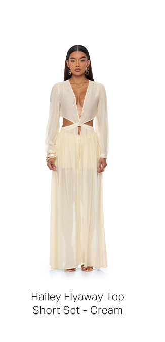 Full-length shot of a woman in a cream Hailey Flyaway Top with waist cut-outs and a matching flowy Short Set. Perfect for women's summer fashion.