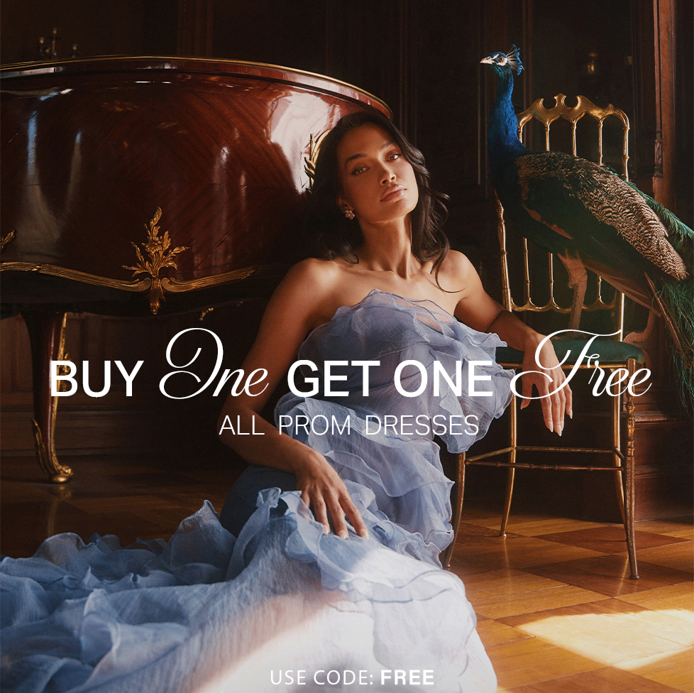 Elegant woman in a flowing light blue prom dress in an opulent setting with a peacock, promoting a BOGO Free prom dresses sale.