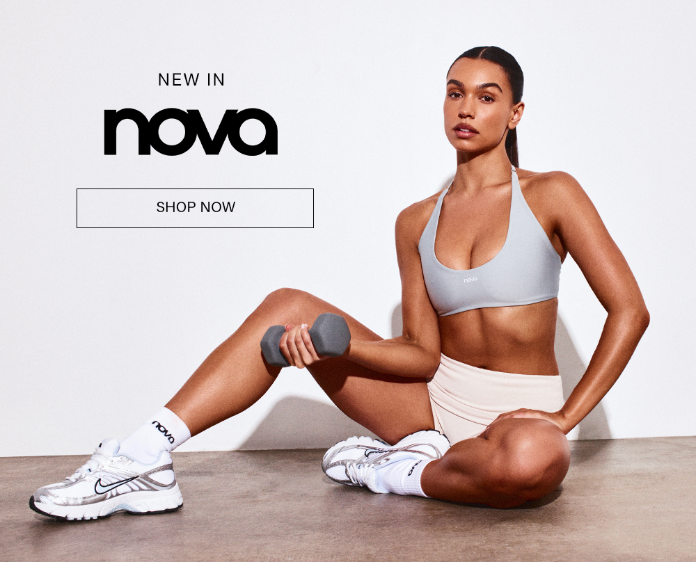 Nova NEW IN: Woman in grey sports bra, shorts, sneakers, holding dumbbell. Shop high-performance women's activewear.