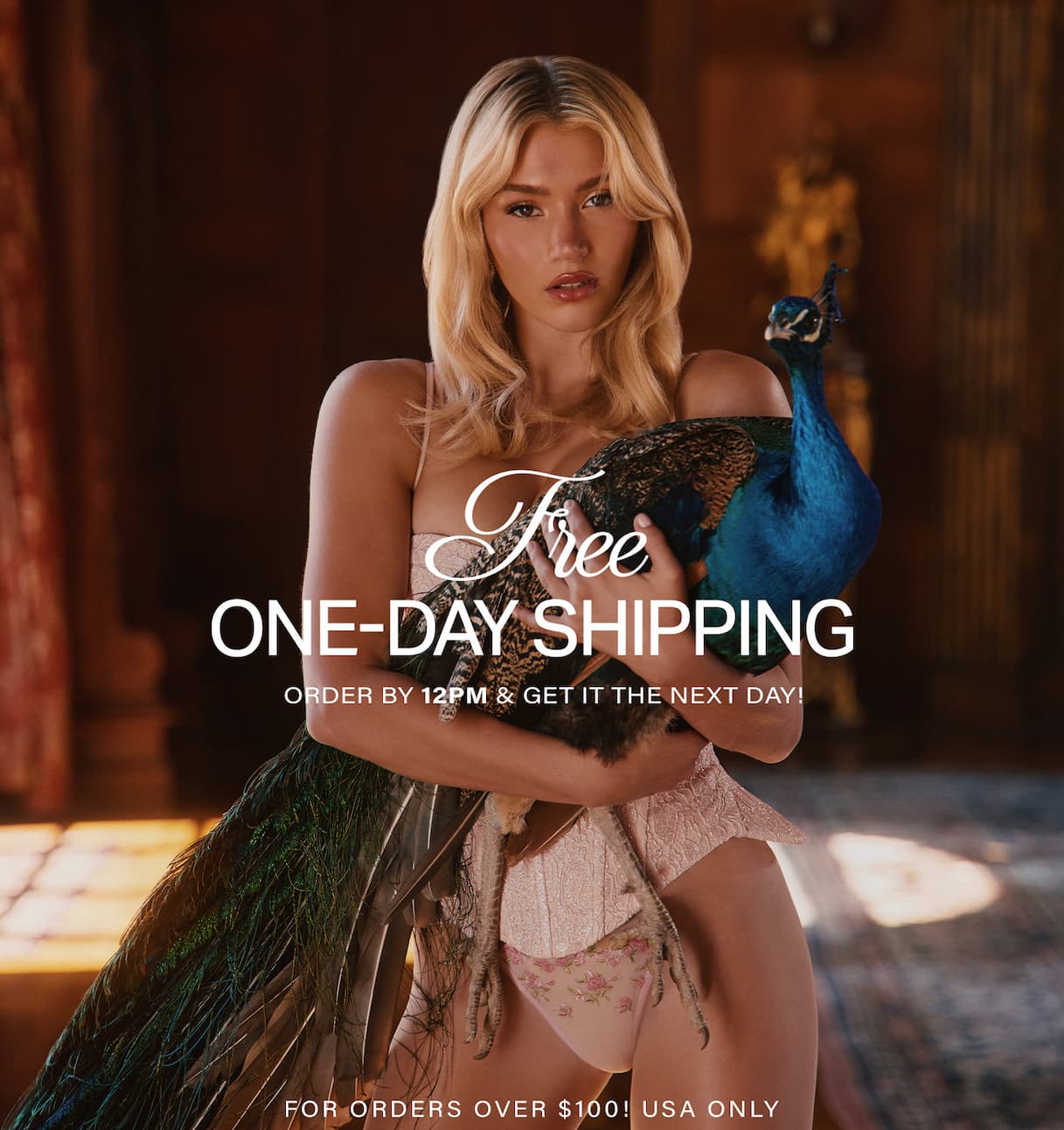 Blonde woman in peach lace lingerie holds a vibrant blue peacock. Get free one-day shipping on luxurious lingerie orders over $100!