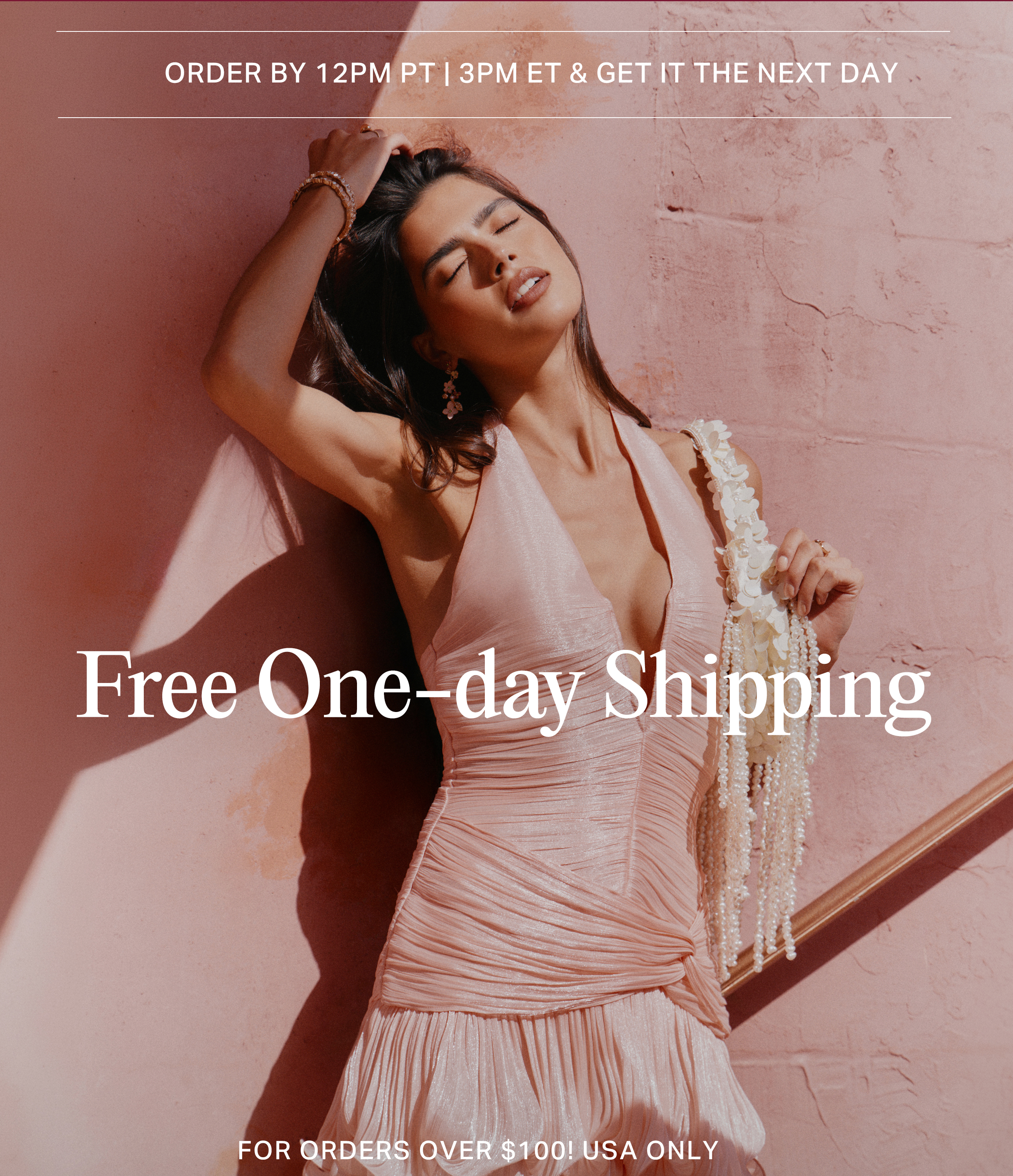 Woman in a stylish pink halter dress poses against a warm pink wall for an ad promoting free one-day shipping on US orders over $100.
