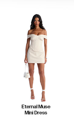 Elegant woman modeling an off-shoulder cream Eternal Muse Mini Dress with a structured corset bodice, white mini bag, and matching heels.
