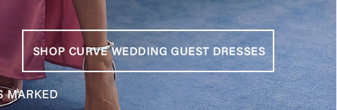 Close-up of a person wearing a flowy pink dress and silver heels on a blue textured floor. Discover and shop curve wedding guest dresses now.